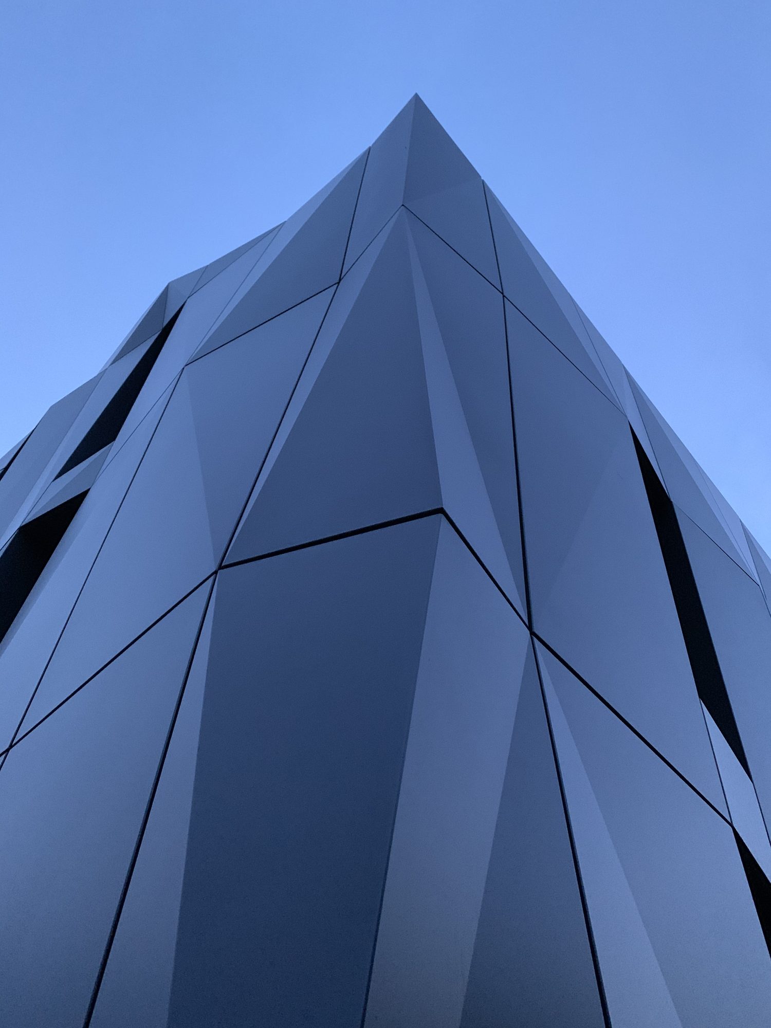 Detailaufnahme der modernen Fassade am Hof, spitz gegen den blauen Himmel